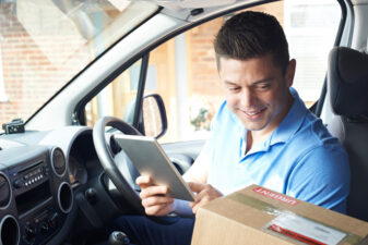 Man looking at his phone near a delivery box