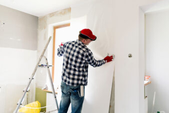 Man gluing down wallpaper