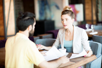 woman and man speaking at a cafe