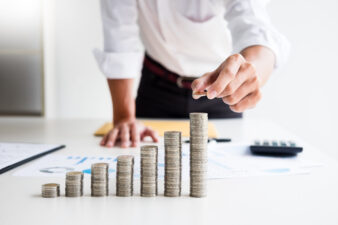 Closeup view of person stacking coins on a table