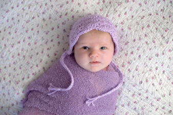 Baby girl swaddled in lavender blanket