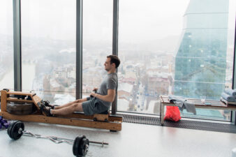 Man working out on row machine in fitness studio