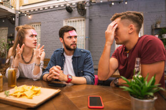 Friends having heated discussion outside at table