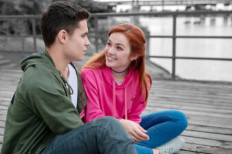 Young couple embracing near brick wall