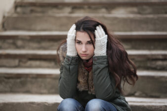 Depressed young woman sitting on stairs