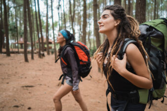 Two female hikers walking through forest