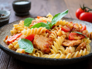 fusilli pasta with tomato sauce, chicken fillet with basil leave