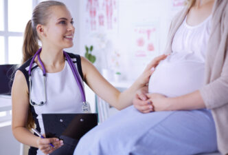 Young female doctor speaking with a pregnant patient