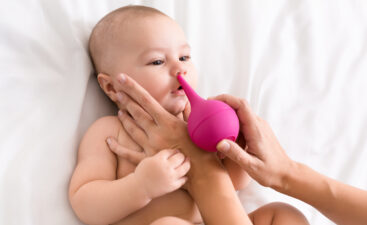 Newborn baby getting nose cleaning with cleaner