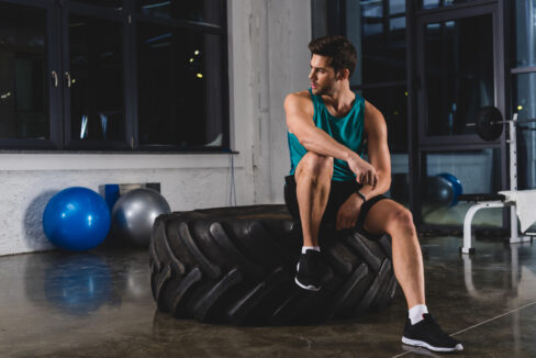 man sitting on exercise equipment