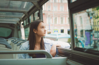 girl looking out the window on a bus