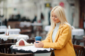 blonde woman sitting alone at a cafe