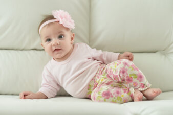 Cute baby girl lying on couch