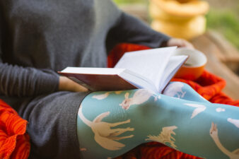 woman holding a cup of coffee and a book