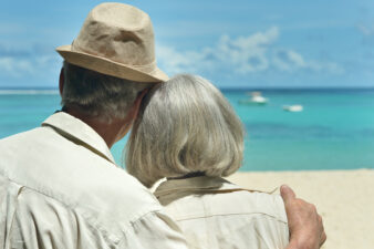 Elderly couple looking at the water on a beach