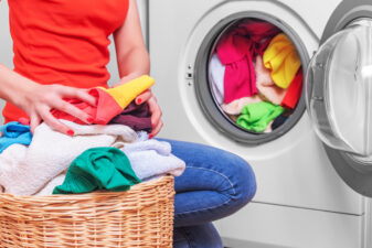 Woman putting laundry into the machine