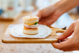 mini slider on a wood cutting board held by female hands