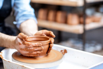 Hands making clay pottery