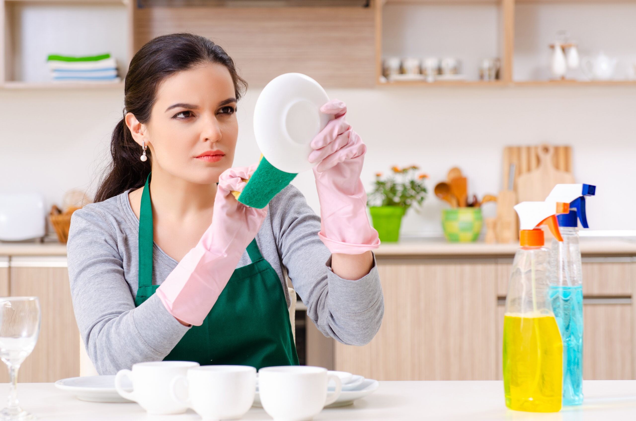 Young female meticulously cleaning a white plate