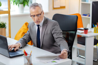 Busy gray-haired man working at his desk