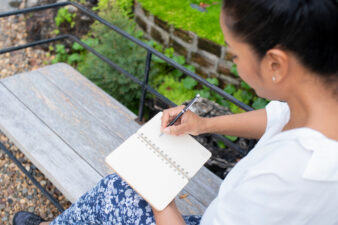 Woman journaling on a bench