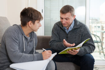 Man tutoring a teenage boy