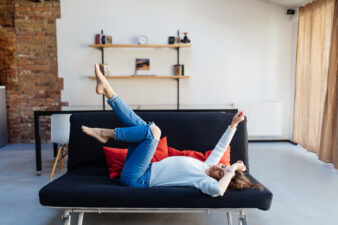 Woman lying down on the couch with her legs in the air