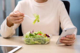 woman eating a takeout salad