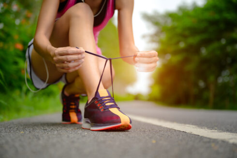 woman lacing up her gym shoe