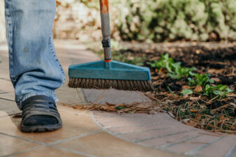 Man sweeping fallen leaves