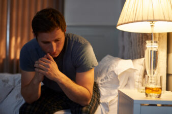 Depressed man in bedroom at night