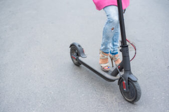 Female in high heels holding a scooter