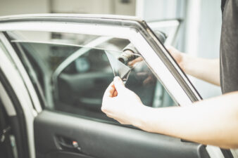 Person removing film on car window