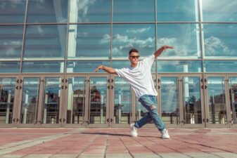 Man dancing outside a building downtown