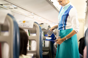 Female flight attendant pouring drink