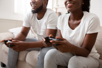 Black couple playing video games at home