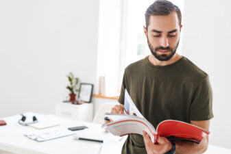 man standing up and reading