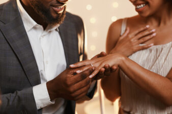 black man putting a ring on his new bride