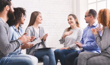 Happy woman sharing her progress with group in rehab