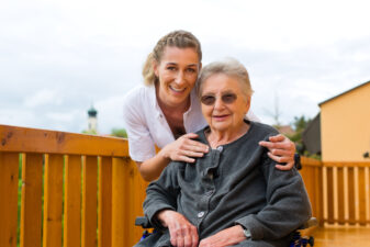 Young nurse and female senior in a wheel chair going for a walk