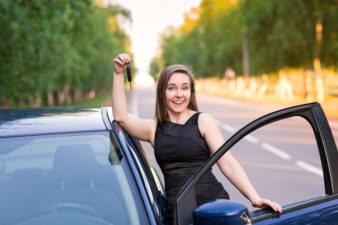 Woman holding her car keys outside of her car