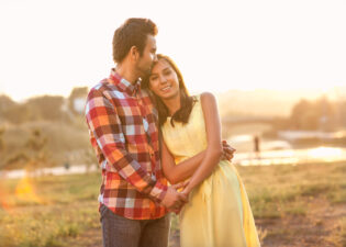 young couple hugging outside