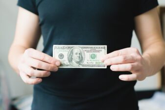 man holding $100 bill