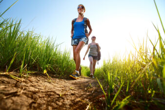 Two women hiking on a grassy path