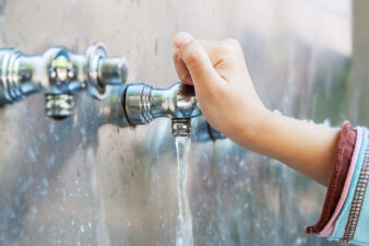 Hands turning a faucet