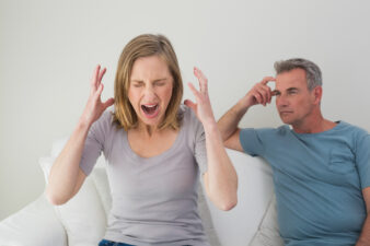 Woman screaming with a frustrated man in background