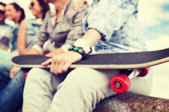 close up of female hand holding skateboard