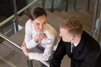 Business woman and man having a conversation by a railing