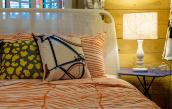 colorful pillows on bed with white lamp