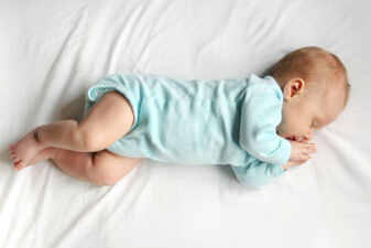 Sleeping baby in a blue onesie